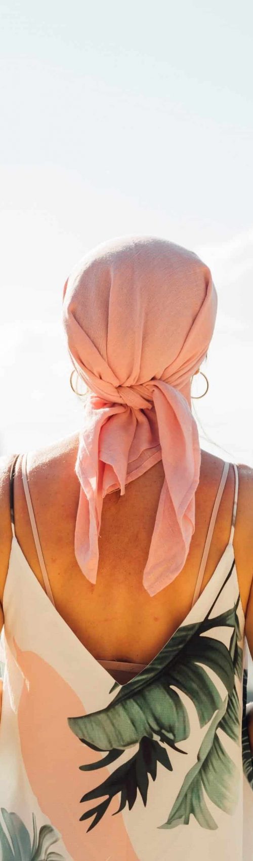 Woman with pink headscarf looking at the horizon. Cancer concept
